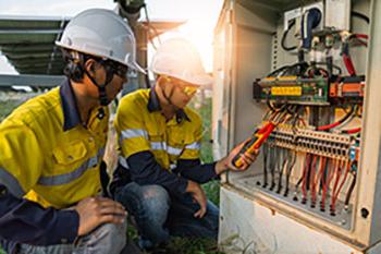 Occupation Safety professionals using clamp meter to measure current.